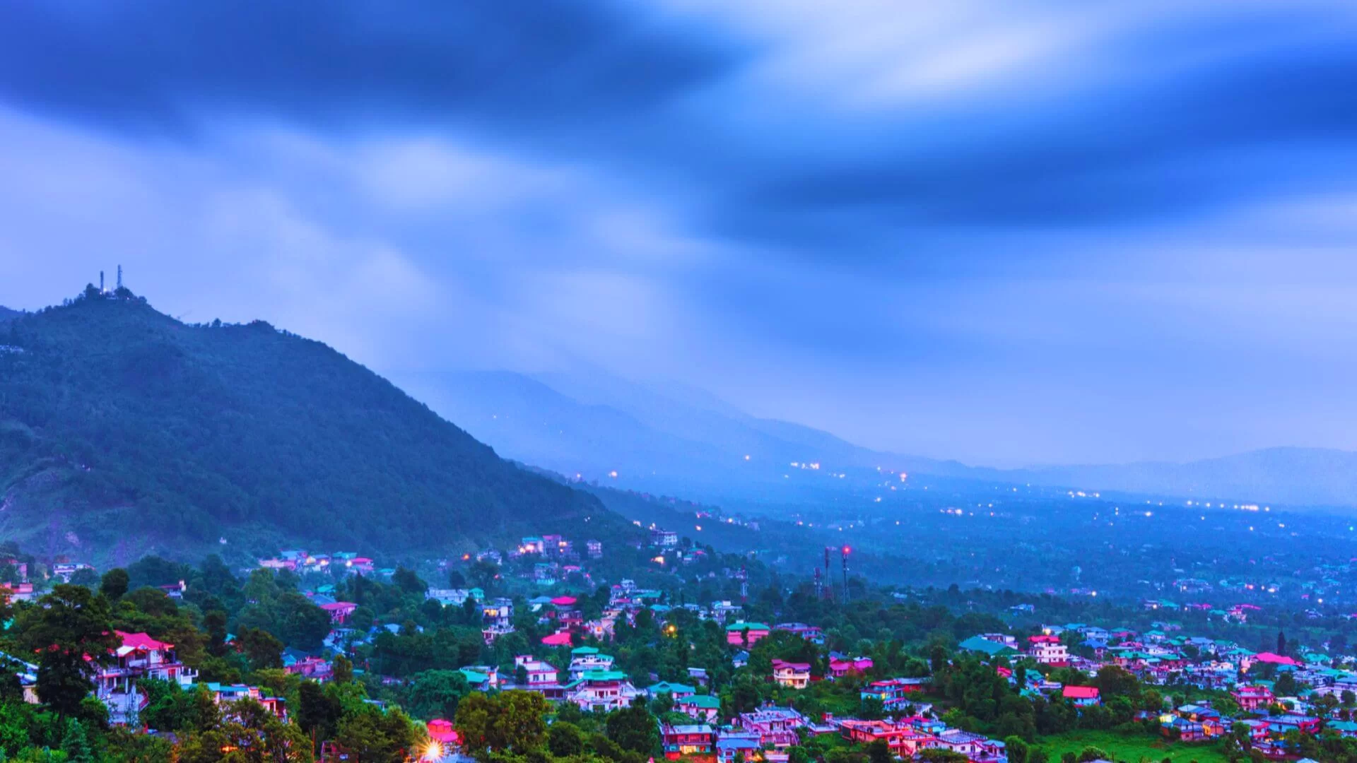 Rain-soaked green hills in Dharamshala during the monsoon season, showing changing weather conditions