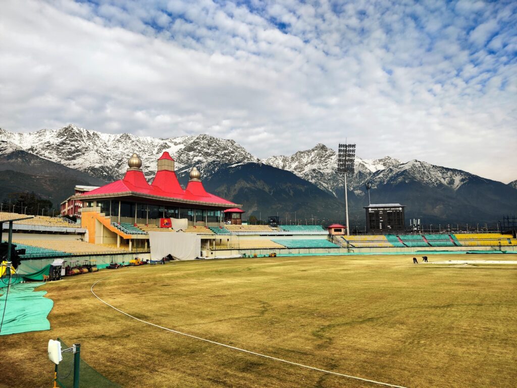 Dharamshala cricket stadium with snow-capped Dhauladhar mountains in the background