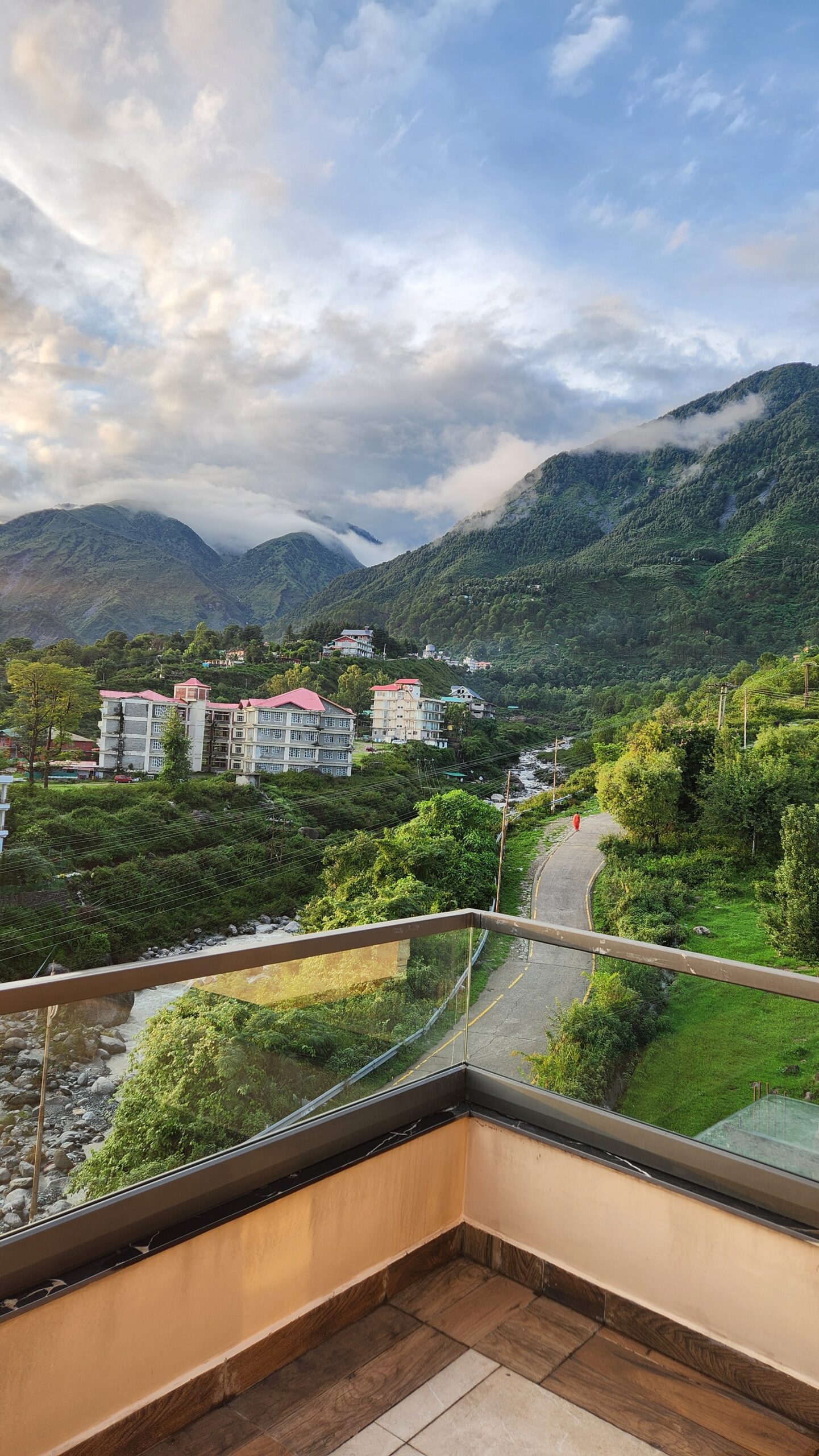 Valley view from Manoratham homestay in Khaniyara, Dharamshala, overlooking a quiet road, river, and green hills