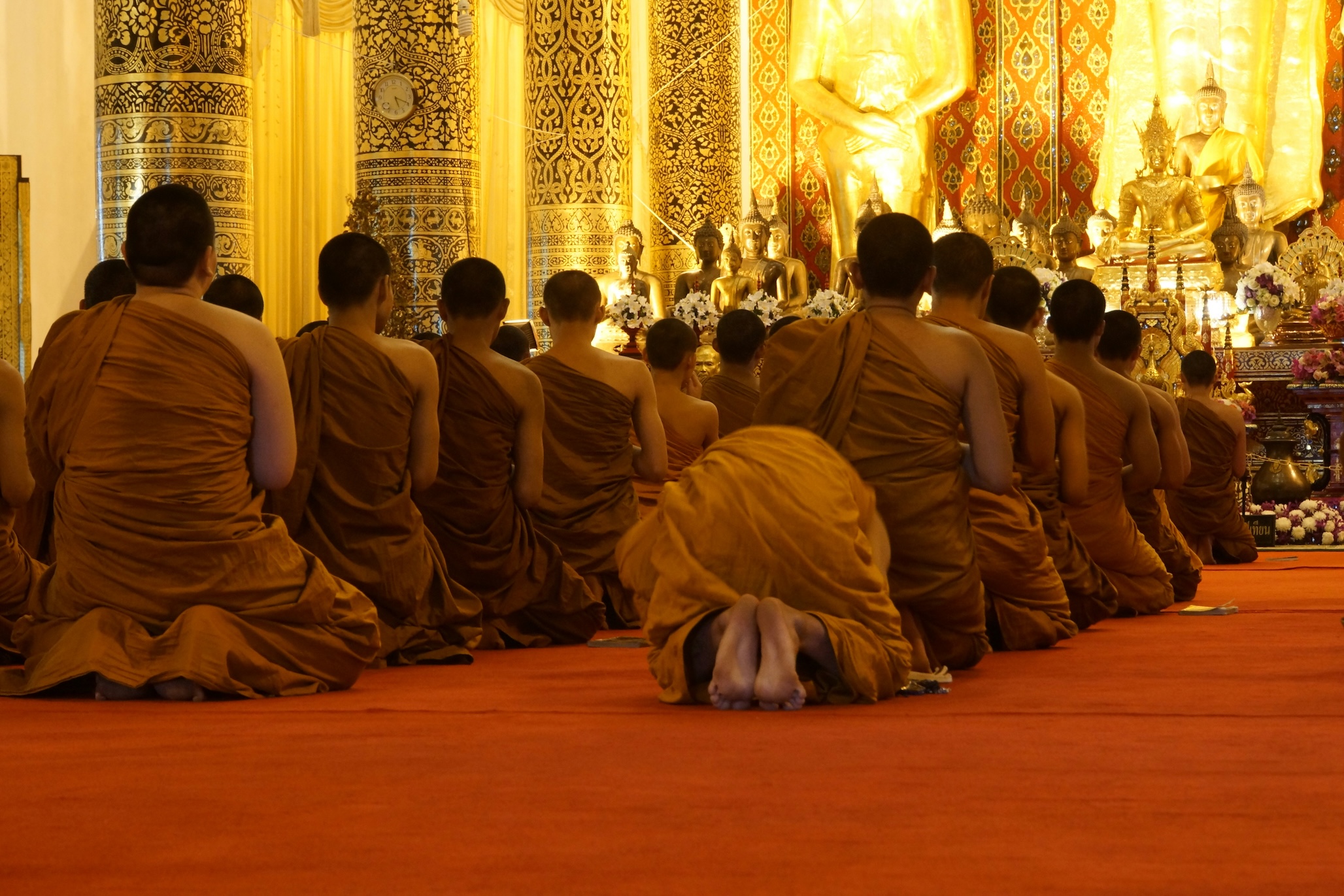 Monks seated in prayer inside a Buddhist monastery, reflecting daily life in Tibetan monasteries
