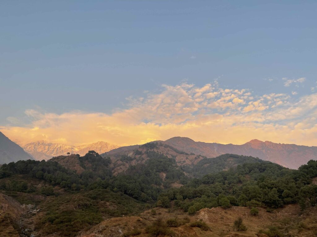 Golden sunset over the Dhauladhar mountains and forested hills near Khaniyara village in Dharamshala