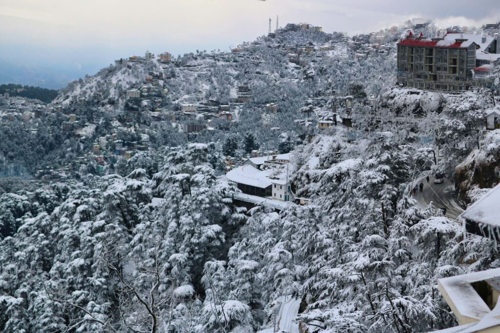 Snowfall in Dharamshala covering hills and homes, showing how internet and power in Dharamshala can be affected during winter conditions