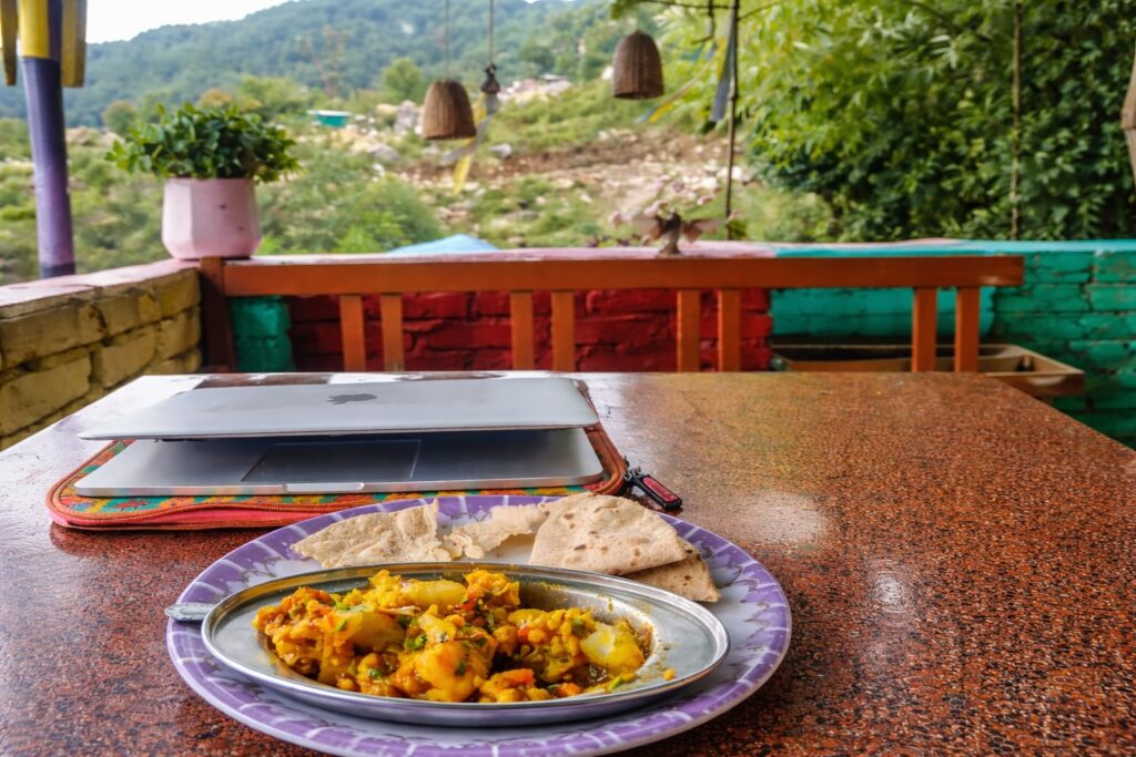 famous food in Dharamshala cafe meal with mountain view and laptop setup