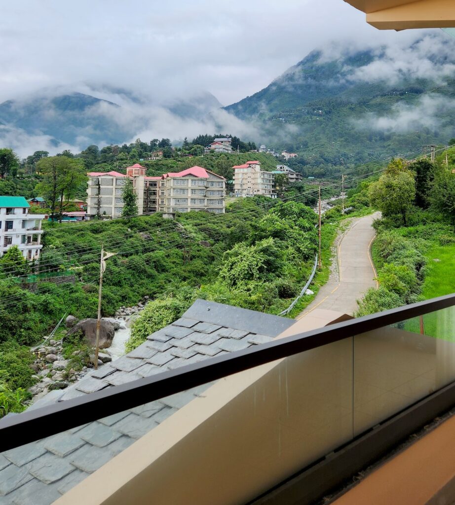 Balcony view from Manoratham Airbnb in Dharamshala overlooking mountains and greenery, ideal for Dharamshala IPL match 2026 stay
