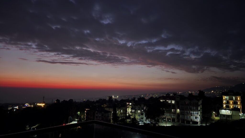 solo female traveller Dharamshala night view low light hillside town