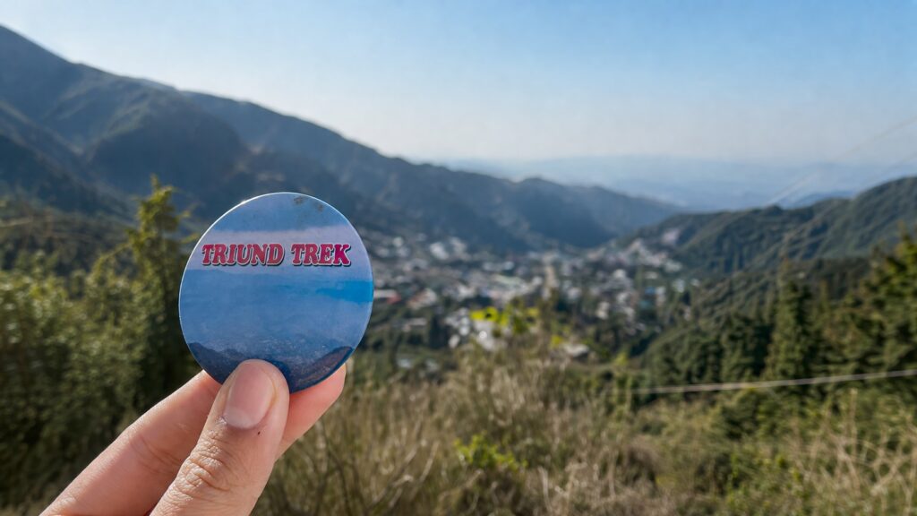 Triund Trek Dharamshala starting view with trek badge and valley landscape in background