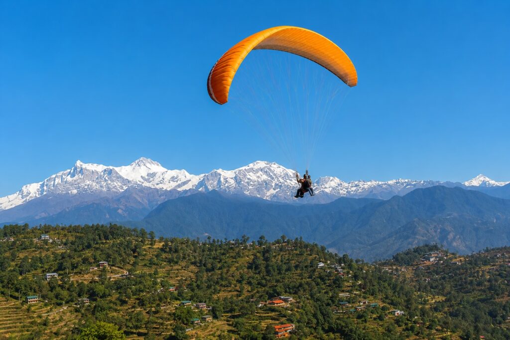 Dharamshala in June with paragliding over the Kangra Valley and snow-capped Himalayan mountains