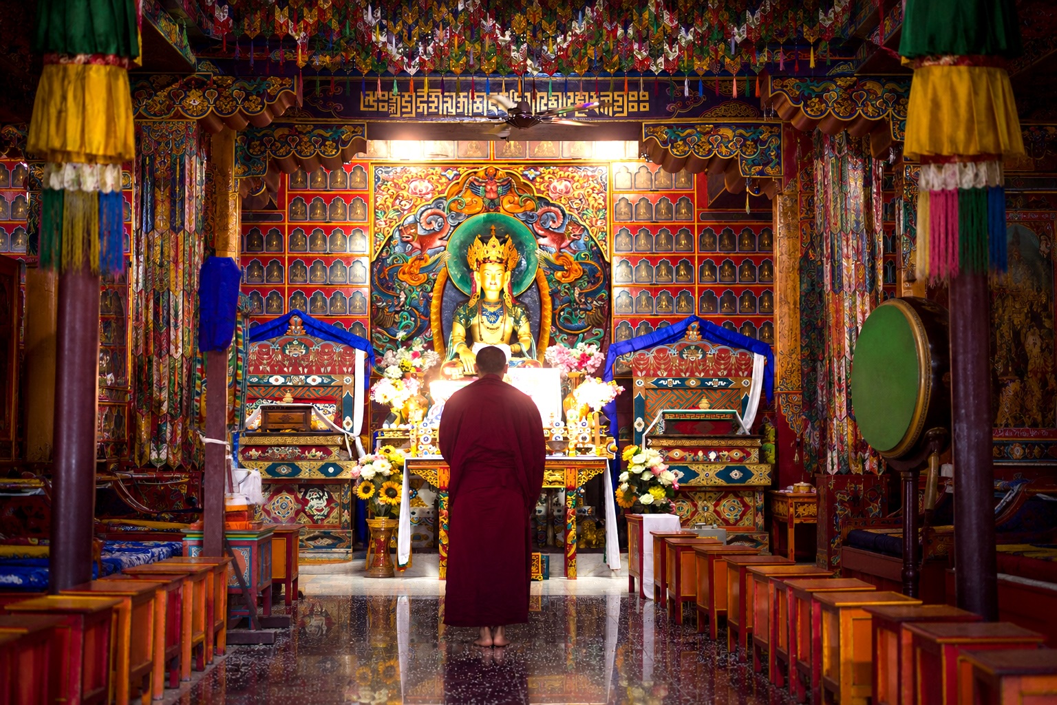 Where to stay for Dalai Lama Birthday 2026, Tibetan monastery interior in Dharamshala with monk praying