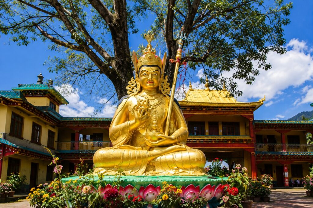 Golden Buddhist statue in the courtyard of Chokling Monastery in Bir, Himachal Pradesh.