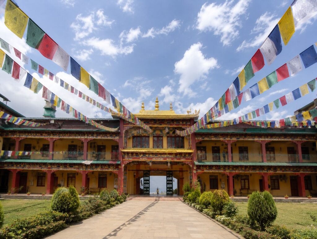 Courtyard of Chokling Monastery in Bir, the filming location of The Cup, with prayer flags and traditional Tibetan architecture.