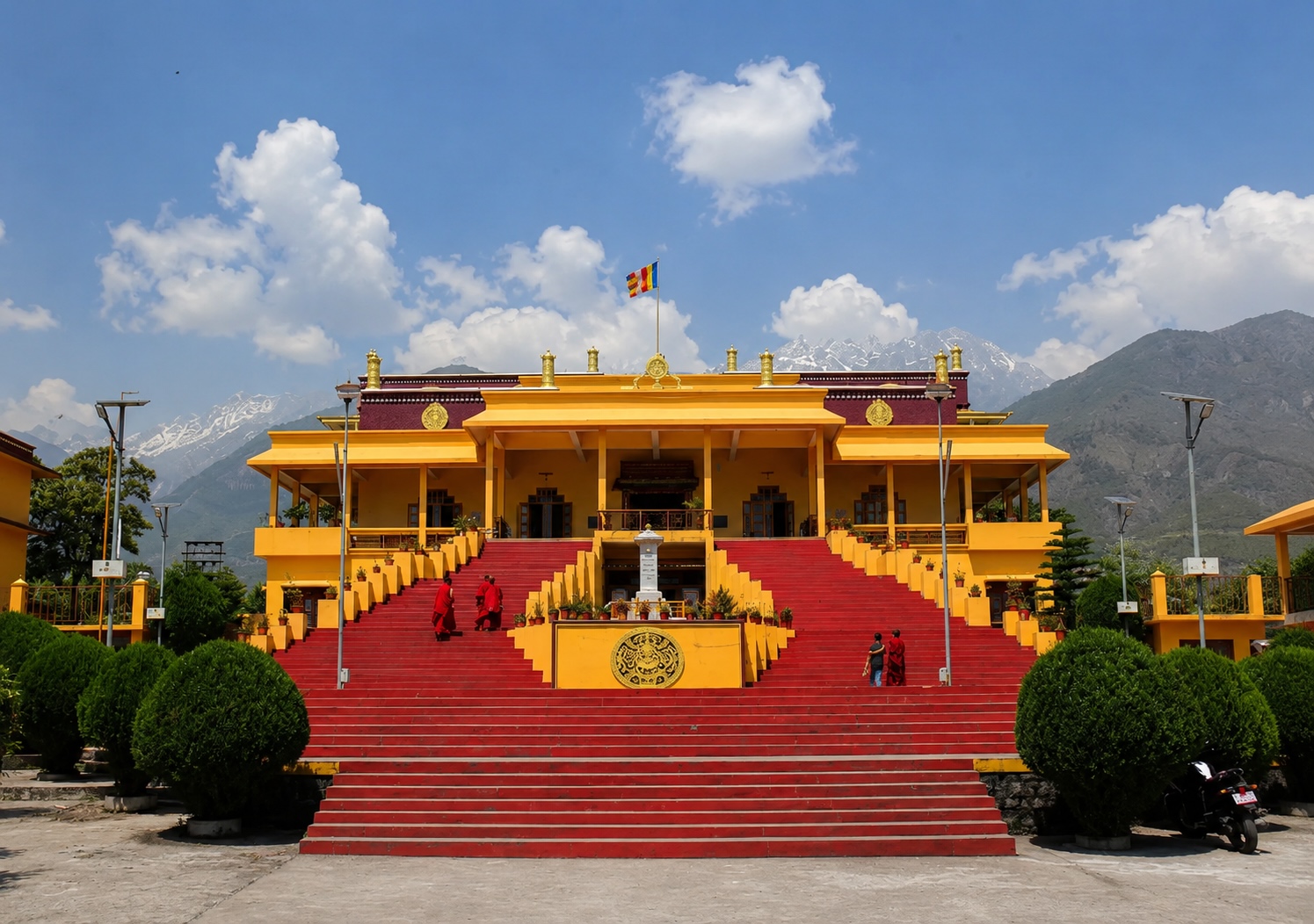 Namgyal Monastery in McLeod Ganj Dharamshala with monks on the staircase and Dhauladhar mountains in the background