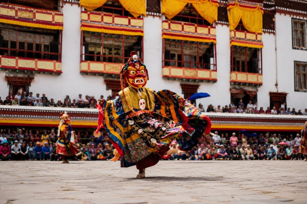 Masked monk performing a cham dance at Sherabling Monastery during a Tibetan Buddhist festival in Bir