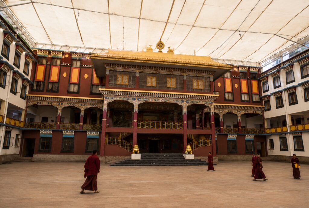Monks walking through the main courtyard of Sherabling Monastery in Bir, Himachal Pradesh