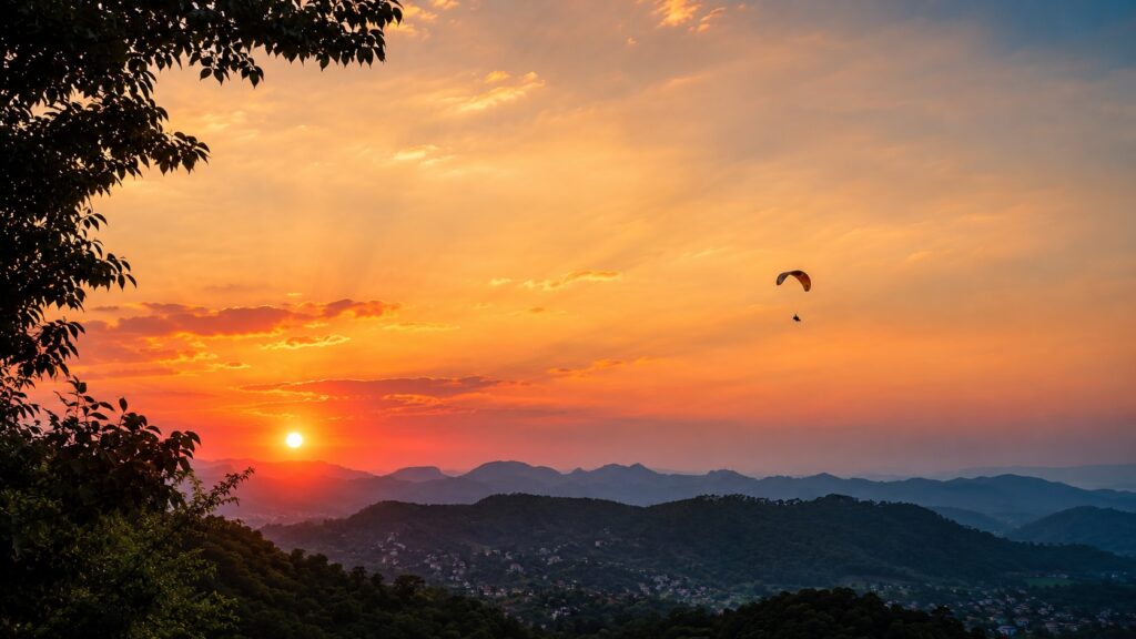 Bir Billing paragliding at sunset with a lone paraglider flying above the Bir valley in Himachal Pradesh.