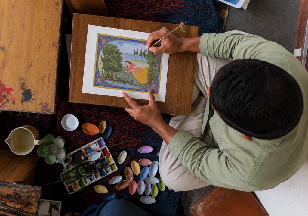 Artist creating a traditional Kangra painting with a fine brush